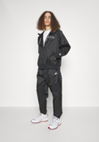 Nike Sportswear WINDRUNNER - Tracksuit bottoms - black/white