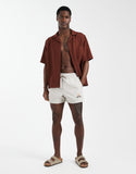 ASOS DESIGN swim shorts in short length with embroidery in beige